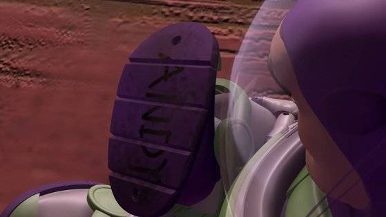 우디의 이야기를 들으며, 장난감으로의 정체성을 확인하는 버즈. 발바닥엔 장난감 주인, 앤디의 이름이 선명합니다. [토이 스토리 캡처]