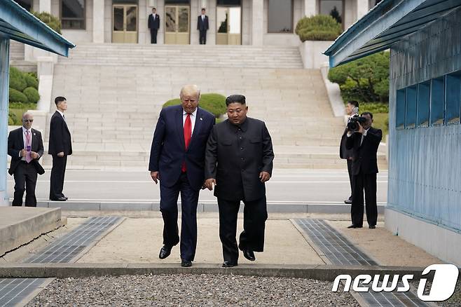 도널드 트럼프 미국 대통령이 30일 오후 판문점을 방문해 북측에서 악수를 나눈 후 김정은 북한 국무위원장과 함께 남측으로 넘어오고 있다 © 로이터=뉴스1 © News1 이동원 기자