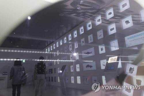 지난 1일 오후 서울 서초구 삼성전자 딜라이트 샵에 전시된 반도체 웨이퍼에 비친 전시품과 관람객 모습. [연합뉴스 자료사진]