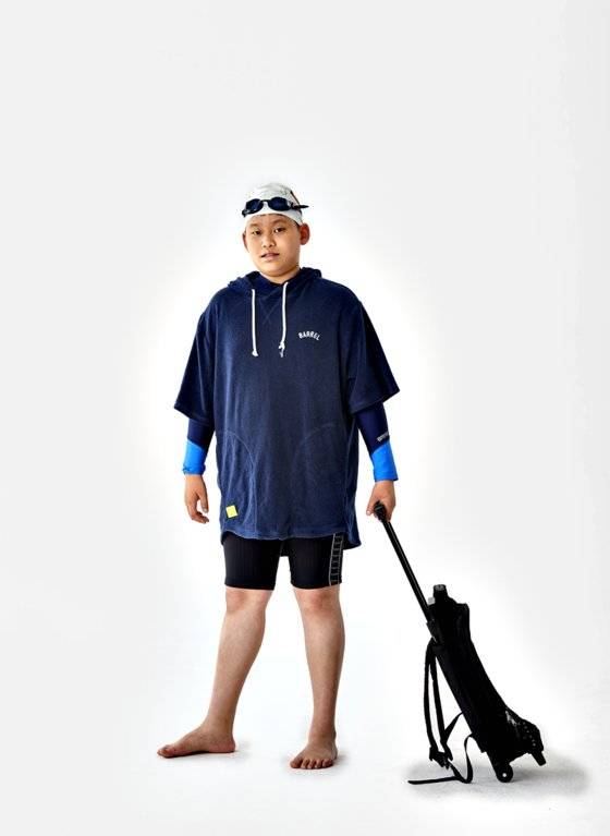 한승민 학생기자가 판초형 수건을 입었다. 안에 입은 건 본인 소장품 래쉬가드 수영복이다. 수영을 마친 후 물이 마를 때 감기에 걸릴 위험이 있는데 이 때 물기를 수건으로 닦으면 그럴 걱정을 덜 수 있다는 게 한 학생기자의 생각이다.