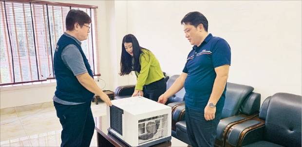 이용정 센추리산업 대표가 천안 본사 사무실에서 직원들과 엘리베이터 에어컨을 점검하고 있다.  /충남테크노파크 제공