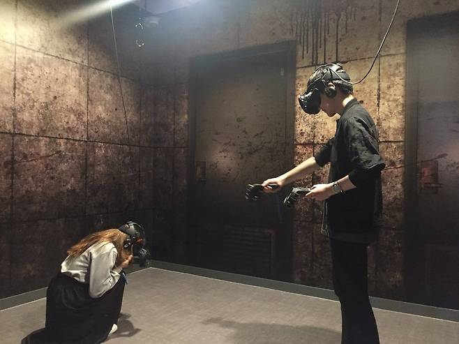 브이아르(VR) 스퀘어 홍대점에서 방탈출 공포 게임 ‘더 도어’를 하고 있는 이용자들. 사진 스코넥엔터테인먼트 제공