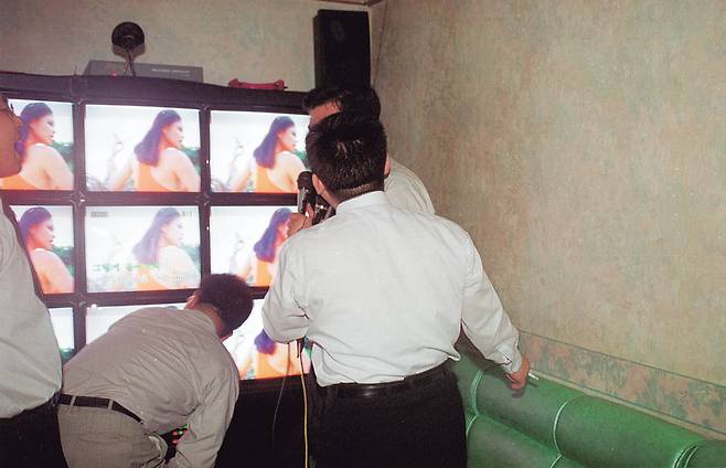 한때 직장에서는 노래방에서 윗사람의 기분에 잘 맞춰 노는 것도 능력으로 인정받았다. 여직원과 블루스를 추거나 도우미를 부르는 것도 낯설지 않았다. 사진은 1990년 초반 노래방에서 노래를 부르는 직장인 모습. 연합뉴스