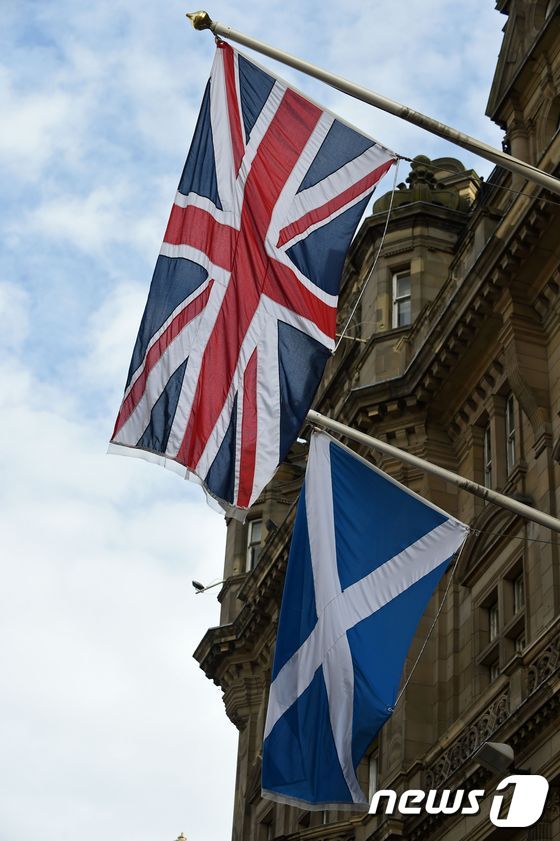영국 국기(위) 와 스코틀랜드기. / AFP PHOTO / Lesley Martin