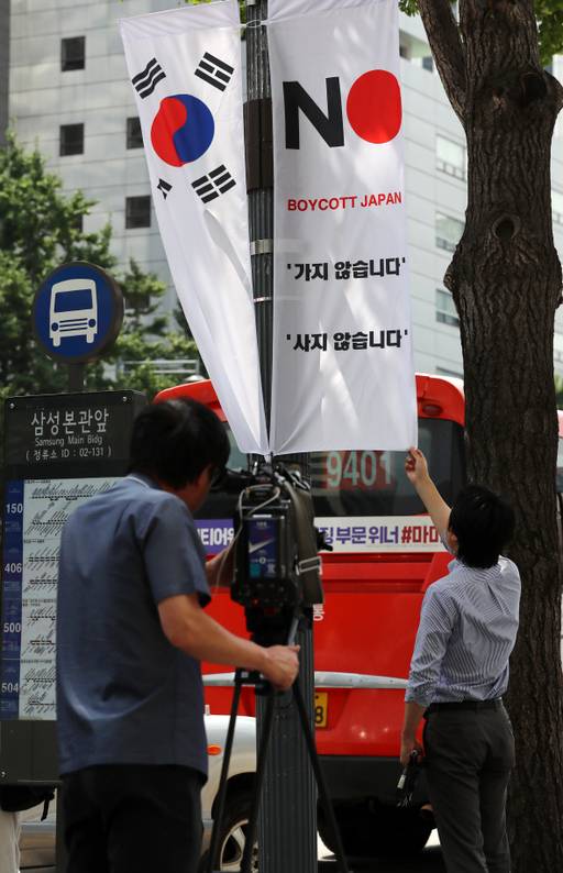 일본 취재진이 6일 서울 중구의 한 대로변에 내걸린 '노 재팬' 배너기를 촬영하고 있다. 연합뉴스