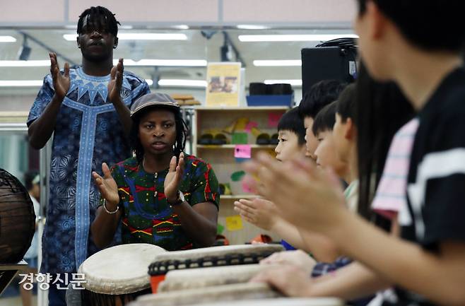 아미두가 어린이들에게 젬베를 가르치며 음악수업을 하고 있다.