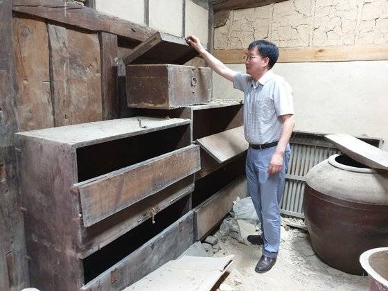 최창호 경주최부자민족정신선양회 이사가 지난해 7월 28일 경주 교동의 최부자댁 곳간에 있는 나무궤짝에서 서류더미를 발견했다. [사진 경주최부자민족정신선양회]