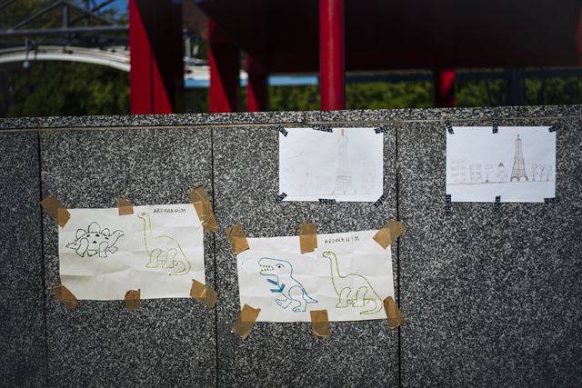 프랑스 파리의 포르트 드 라 빌레트 부근에서 26일(현지시간) 노숙자 가족을 위한 임시 캠프 앞에 아이들이 그린 에펠탑과 공룡 그림이 붙어 있다. 중동과 아프리카에서 온 대부분 가족으로 구성된 약 200여명의 이민자들이 공원구역에 설치된 새로운 임시 야영지에 모여 있다. AP 연합뉴스