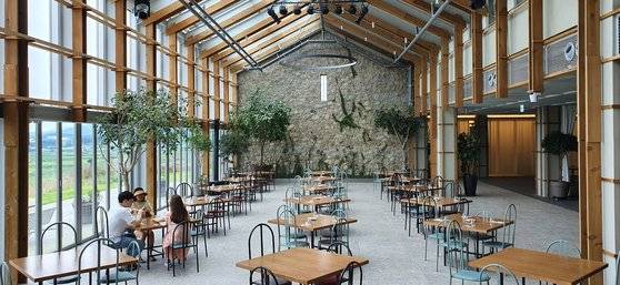 전북 고창 '상하목장' 내에 위치한 호텔 파머스 빌리지 1층. 천장과 한쪽 벽면을 통창으로 마감해 기분 좋은 온실 분위기를 만들었다. 아침엔 조식 뷔페 식당, 오후엔 카페로 이용된다. 투숙객이 아니어도 사용할 수 있다.