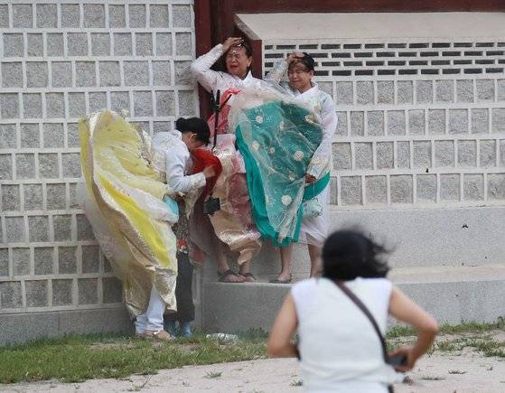 7일 오후 서울 경복궁에서 관광객들이 강풍을 피하고 있다. [연합뉴스]