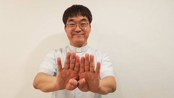 박민서 신부가 수어로 ‘서로 닫힌 마음을 열어보세요’라고 말하고 있다.