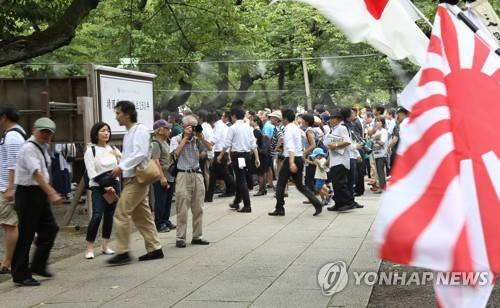 일본의 패전일이자 한국의 광복절인 지난달 15일 일본 도쿄(東京) 야스쿠니신사(靖國神社)에서 전범기인 욱일기(旭日旗)가 휘날리는 가운데 참배객들이 걸어가는 모습 [연합뉴스 자료사진]