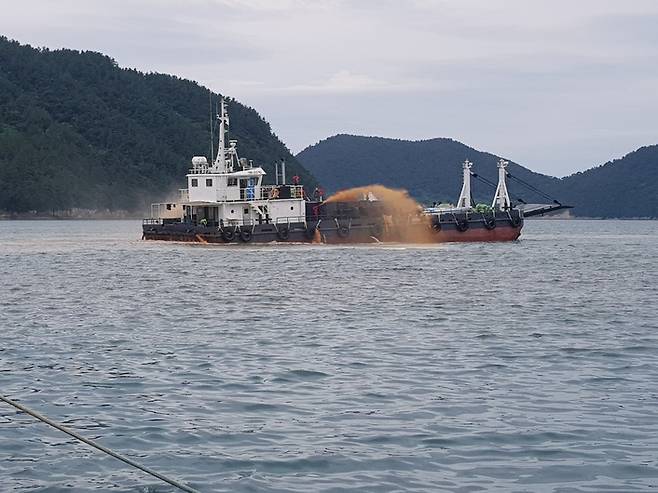 선박이 적조 피해를 막기 위해 양식장 인근 해역에 황토를 뿌리고 있다. 전남도청 제공