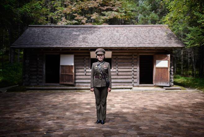 지난 12일 삼지연의 김일성 주석의 비밀 캠프이며 김정일 국방위원장이 태어났다는 오두막 앞에서 안내원 김은심(23)이 포즈를 취하고 있다. [AFP=연합뉴스]