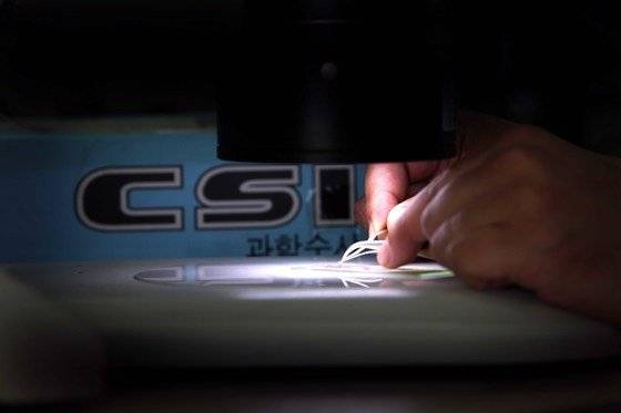 경찰 CSI 요원이 첨단 장비를 이용해 각종 증거물에서 범인의 흔적을 찾아내고 있다. [중앙포토]