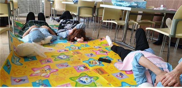 서울대 학생식당과 카페 등에서 일하는 민주노총 전국대학노조 서울대지부 소속 생활협동조합 노동자들이 23일 서울대 관악캠퍼스 행정관 앞에서 기자회견을 열고 임금 인상과 노동 환경 개선을 요구하며 무기한 파업을 선언했다. 노동자들이 식당 바닥에 돗자리를 깔고 드러누워 휴식을 취하고 있다.민주노총 제공