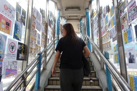 한 여성이 홍콩 코스웨이베이역 근처 육교 계단을 올라가며 유리창에붙어 있는 홍콩 시위 지지 게시물들을 보고 있다. /홍콩=김남희 특파원