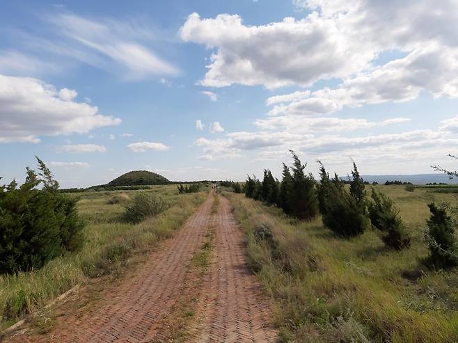 5세기 북위의 여걸 권력자였던 문명태후 풍씨의 무덤 영고릉으로 가는 길. 사진 위 길옆으로 멀리 보이는 동산 같은 곳이 영고릉이다. 옛 도읍 평성이었던 다퉁 북쪽에서 다퉁분지를 내려다보는 표고 1450m의 방산 정상에 자리잡은 이 무덤은 태후가 북위의 지배자로서 생전 누렸던 절대권력을 극명하게 보여주는 상징물이다.