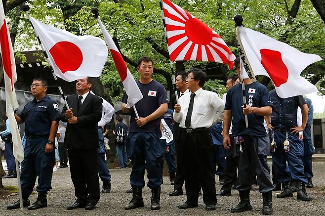 ⓒAP Photo일본의 패전일인 8월15일 야스쿠니 신사에서 우익 세력들이 일장기와 욱일기를 들고 서 있다.
