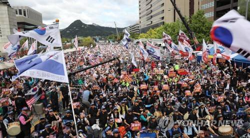 보수단체 광화문 집회 (서울=연합뉴스) 하사헌 기자 = 3일 낮 서울 광화문 교보빌딩 앞에서 열린 '문재인 하야 범국민투쟁 대회'에서 참석 시민들이 태극기와 깃발을 흔들며 구호를 외치고 있다. 2019.10.3 toadboy@yna.co.kr