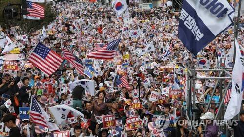 광화문 보수단체 집회 (서울=연합뉴스) 하사헌 기자 = 3일 낮 서울 광화문 교보빌딩 앞에서 열린 '문재인 하야 범국민투쟁 대회'에서 참석 시민들이 태극기와 성조기를 흔들며 구호를 외치고 있다. 2019.10.3 toadboy@yna.co.kr