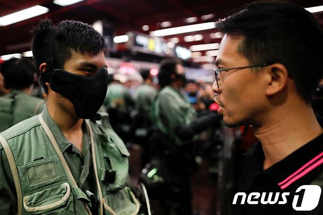 3일 홍콩 시위에서 한 시민이 "경찰부터 복면을 벗으라"며 경찰에게 강력하게 항의하고 있다. © 로이터=뉴스1 © News1