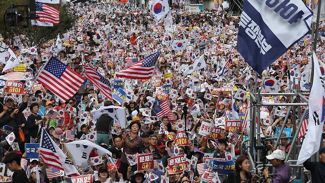 3일 낮 서울 광화문 교보빌딩 앞에서 열린 '문재인 하야 범국민투쟁 대회'에서 참석 시민들이 태극기와 성조기를 흔들며 구호를 외치고 있다. [연합뉴스]