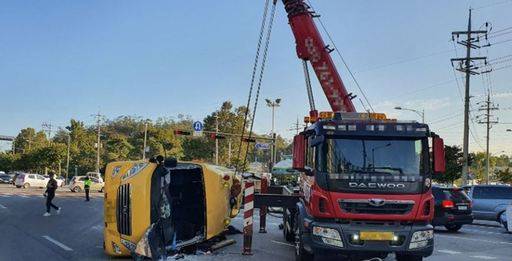 25일 오전 7시26분쯤 서울 송파구 오륜사거리에서 교통사고로 전복된 고등학교 통학버스가 견인되고 있다. 통학버스는 충돌 이후 맞은 편에서 신호 대기 중이던 다른 승용차 1대도 들이받았다. 연합뉴스