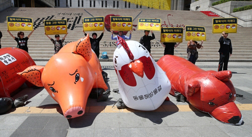 지난 5월2일, 서울 세종문화회관 앞 계단에서 동물해방물결 회원들이 소와 돼지, 닭, 개 모양의 대형 풍선을 설치하고 ‘탈육식’ 캠페인을 벌이고 있다. 연합뉴스