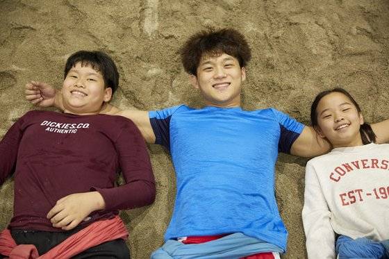 (왼쪽부터)승민, 노 선수, 가영이가 모래판 위에 누웠다. 씨름 선수에게 모래판은 소중한 곳이다.