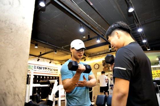 황찬섭 선수가 승민(오른쪽)에게 팔근육을 위한 운동법을 가르쳤다.