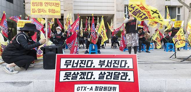 지난 22일 서울 강남구 청담동 도로변에서 청담동 주택가 지하로 수도권광역급행철도(GTX)-A 노선이 통과하는 걸 반대하는 주민들이 '주택붕괴' '열차탈선' 등이 쓰인 깃발을 들고 시위를 벌이고 있다. 이들은 지난 1월부터 세종시 정부청사와 청담동 인근 등에서 100차례 가까이 GTX-A 반대 시위를 벌이고 있다. /김지호 기자