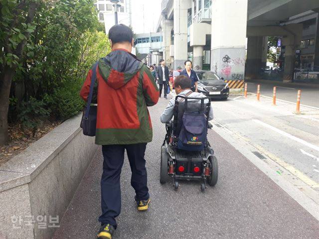 지난달 23일 배재현씨가 휠체어를 충전하기 위해 서울지하철 4호선 노원역 밖으로 나와 7호선 노원역으로 이동하고 있다. 손성원 기자