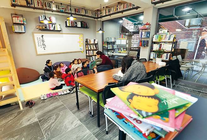 당산1동 ‘나쁜 카페’가 떠난 자리에 만들어진 ‘책나무 마을도서관’에서 9일 오전 아이들이 동화를 들으며 즐거워하고 있다. 정용일 기자 yongil@hani.co.kr