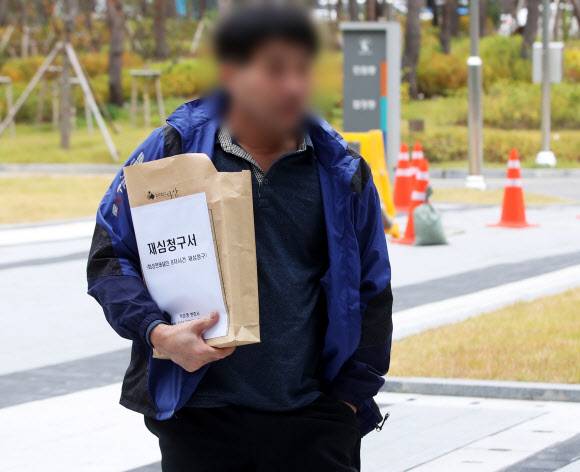 화성연쇄살인 8차 사건의 범인으로 검거돼 20년간 ‘억울한 옥살이’를 했다고 주장해 온 윤모(52) 씨가 재심청구서를 들고 13일 오전 경기도 수원시 영통구 수원지방법원으로 들어가고 있다. 2019.11.13 연합뉴스 화성연쇄살인 8차 사건의 범인으로 검거돼 20년간 ‘억울한 옥살이’를 했다고 주장해 온 윤모(52) 씨가 재심청구서를 들고 13일 오전 경기도 수원시 영통구 수원지방법원으로 들어가고 있다. 2019.11.13 연합뉴스