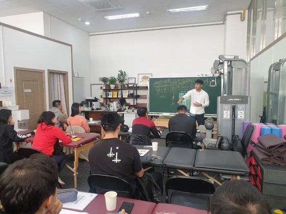 김수범 트레이너의 헬스장엔 녹색 칠판이 놓여져 있다. 사진은 트레이너와 일반인을 대상으로 운동 원리 전반을 강의하고 있는 모습. [사진 유부혁 기자]