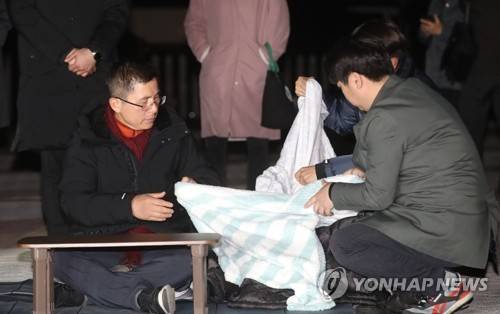 담요 덮는 황교안 (서울=연합뉴스) 신준희 기자 = 3일째 단식 중인 자유한국당 황교안 대표가 22일 오후 청와대 앞 분수대 광장에서 강기정 청와대 정무수석에게 지소미아 효력정지 연기 관련 설명을 들은 후 담요를 덮고 있다. 2019.11.22 hama@yna.co.kr