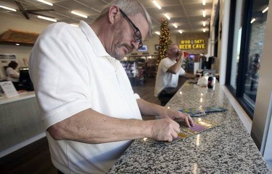 미시시피주 시민들이 25일 복권 판매소에서 즉석복권을 구입해 당첨을 확인하고 있다. [AP=연합뉴스]