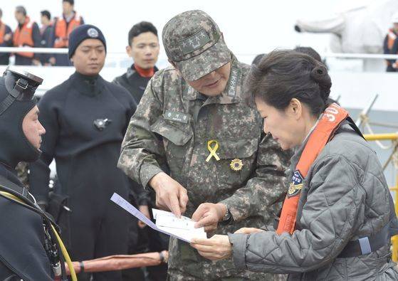 박근혜 전 대통령이 재임 당시 전남 진도해상 '세월호' 여객선 사고 현장을 방문, 민관군 합동 수습작업 중인 바지선에 승선해 당시 해군 참모총장이던 황 전 총장으로부터 보고를 받고 있다. 황 전 총장은 박 전 대통령을 만날때로 군복에 노란 리본을 달았다. [청와대사진기자단]