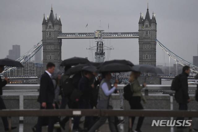【런던=AP/뉴시스】지난 9월30일 심한 폭풍우로 정전이 된 어두운 런던교 위로 퇴근 인파가 걸음을 서두르고 있다. 영국은 10월 내내 악천후에 시달려왔으며 11월2일에는 이달 들어서 심해진 강풍으로 도버해협을 건너는 유럽행 페리 여객선마저 운행이 중단되었다. 2019.11.3
