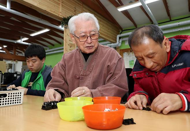 우리마을 촌장인 김성수 주교가 발달장애인들이 두꺼비집 부품을 조립하는 모습을 바라보고 있다. 강재훈 선임기자 khan@hani.co.kr