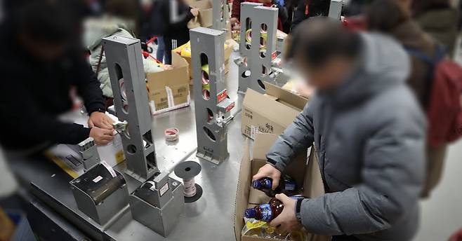 서울 시내의 한 대형마트에서 구매 물품을 담기위해 종이박스를 만들고 있는 시민들. [연합뉴스]