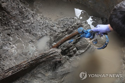 경산 소월리 유적에서 나온 신라 목간 (서울=연합뉴스) 경북 경산 소월리 유적 구덩이에서 신라시대에 작성한 것으로 추정되는 목간을 출토하는 모습. 목간은 서체와 내용 등으로 미뤄 6세기 유물로 보인다. 사진 가운데에 있는 목간 왼쪽에 나무묶음이 있다. [오세윤 작가·화랑문화재연구원 제공. 재판매 및 DB 금지] photo@yna.co.kr