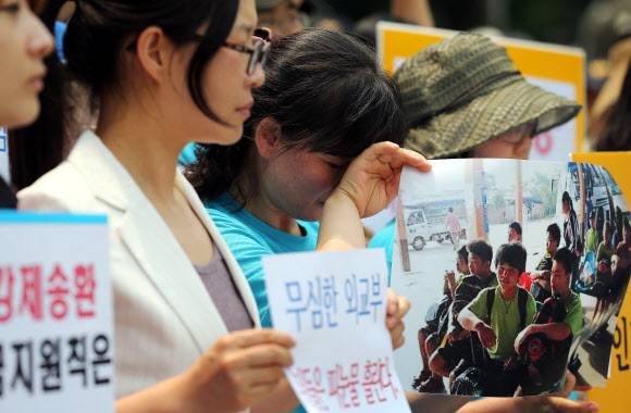 - 2013년 6월 5일 오후 서울 세종로 외교부 청사 앞에서 시위를 벌이던 탈북민 고미화씨가 라오스에서 북한으로 강제 송환된 청소년들의 사진을 든 채 눈물을 흘리고 있다. 이날 시위를 벌인 ‘자유와 인권을 위한 탈북자연대’ 소속 탈북민과 북한 인권단체 회원들은 탈북 청소년 강제북송과 관련해 외교부의 소극적인 대응을 규탄했다. 연합뉴스 2013.06.05