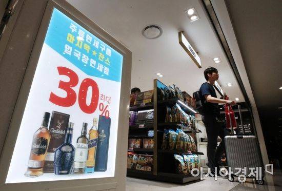 31일 인천국제공항 제1여객터미널에 개장한 입국장면세점에서 여행객이 면세품을 구매해 나오고 있다./영종도=김현민 기자 kimhyun81@