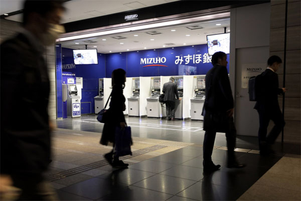 `제로금리의 공습`을 겪고 있는 일본 도쿄 내 한 지하상가에 위치한 미즈호은행 자동화기기
(ATM) 앞을 시민들이 지나가고 있다. [사진 제공 = 블룸버그]