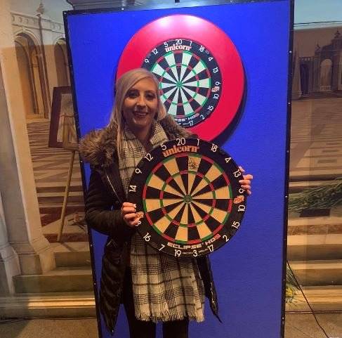 셔록이 1차전 우승할 때 사용했던 다트 보드를 들고 기념촬영하고 있다. 그녀는 이 다트 보드를 경매에 내놓았다. 수입금은 전액 자선단체에 기부할 예정이다. [사진 트위터]
