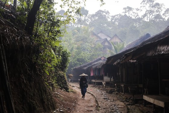 바두이족의 한 여성이 야자나무 껍질로 만든 차양 큰 모자를 쓰고 마을을 거닐고 있다 .[EPA=연합뉴스]