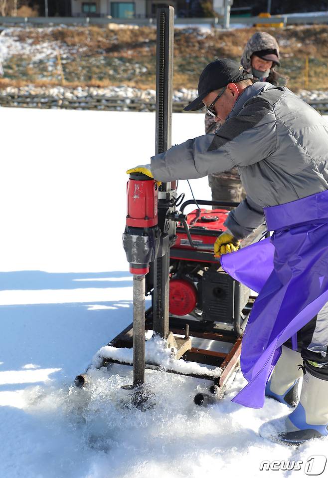 제13회 평창송어축제 개막 하루를 앞둔 27일 축제 관계자들이 강원도 평창군 진부면 오대천에서 물을 빼 얼음을 더 단단하게 얼리는 작업을 하고 있다.2019.12.27/뉴스 © News1 권혜민 기자