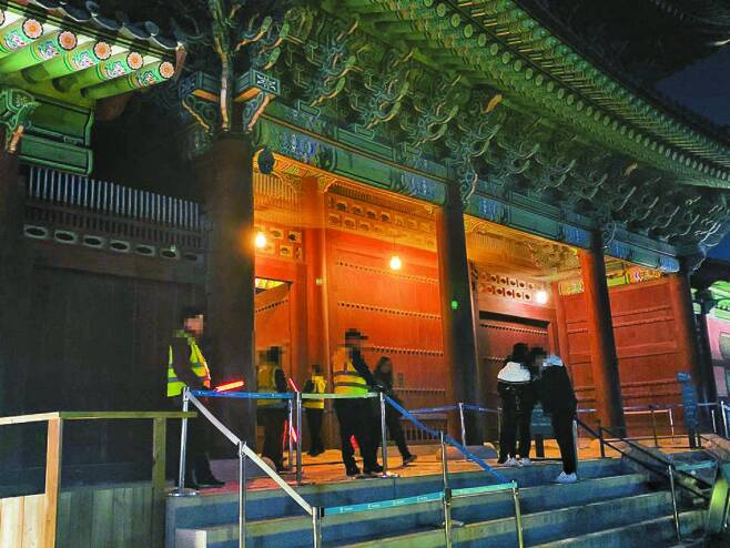 노인 일자리 사업으로 고용된 안내 요원들이 야간 개장한 서울 시내 한 고궁에서 관람객의 입장권을 검사하고 있다. 허정원 기자